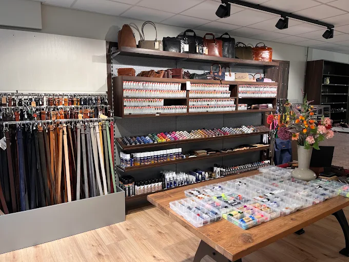 Werktafel met leerverzorgingsproducten en gereedschap bij Schoenmakerij Zeist